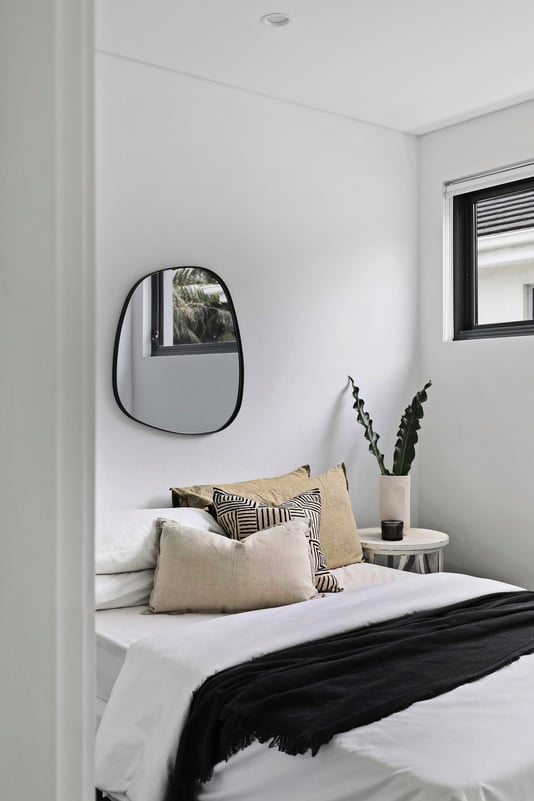 Decorative mirror positioned towards a window to create a green reflection and add light to the room 